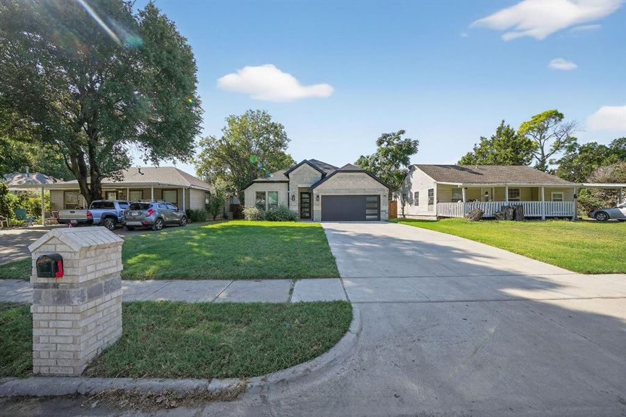 Single story home featuring concrete driveway, a front lawn, and a porch