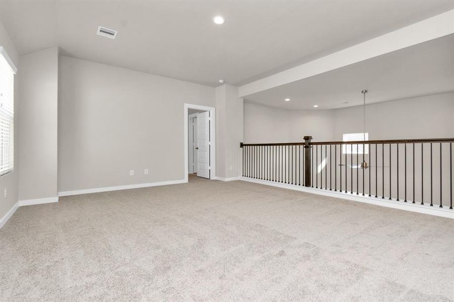 Ascend to relaxation in this fantastic game room! Ideal for both casual gatherings and adult gaming, it boasts plush carpet, lofty ceilings, custom paint, and ample windows for abundant natural light. Sample photo of completed home with similar floor plan. As-built interior colors and selections may vary.