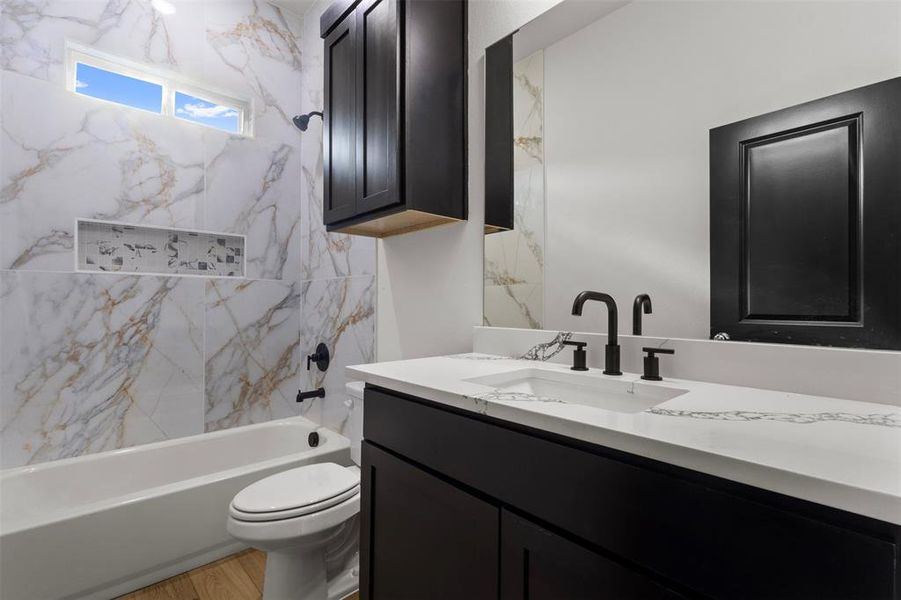 Full bath with shower / bath combination, vanity, and light wood-type flooring