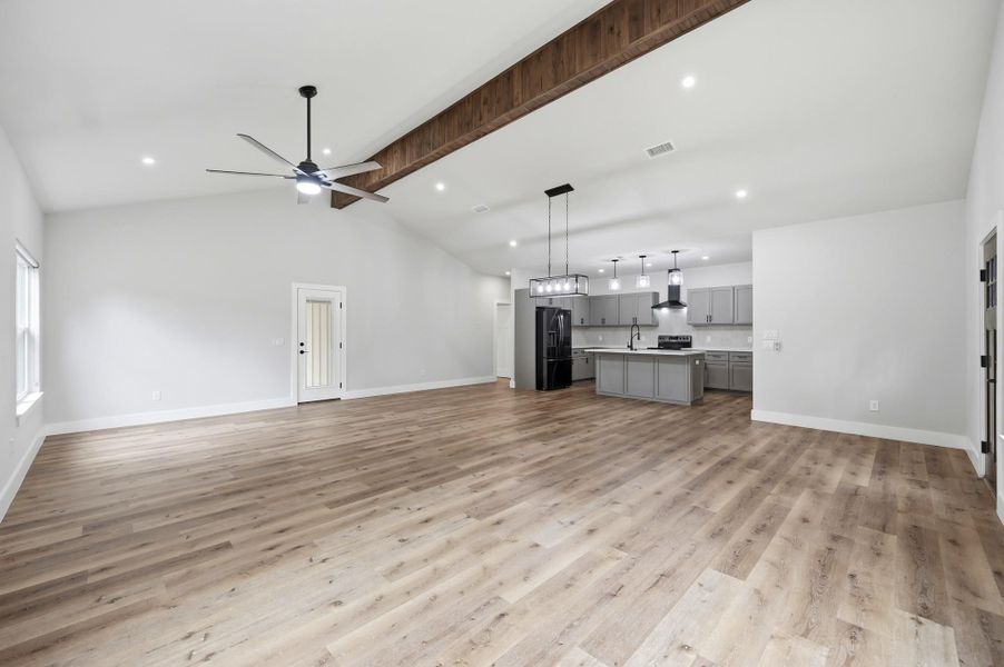 An open-concept living space features vaulted ceilings and a well-appointed kitchen. An open-concept living space features vaulted ceilings and a well-appointed kitchen.