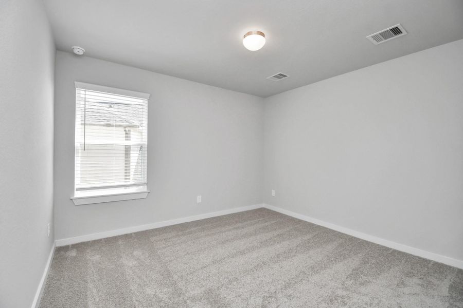 Secondary bedroom features plush carpeting, large windows that let in plenty of natural light, bright paint, and spacious closets. Sample photo of completed home with similar floor plan. Actual colors and selections may vary. Secondary bedroom features plush carpeting, large windows that let in plenty of natural light, bright paint, and spacious closets. Sample photo of completed home with similar floor plan. Actual colors and selections may vary.
