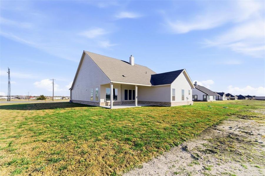 Back of property featuring a yard, a patio, and a chimney