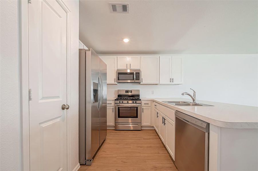 The light and bright kitchen features a conveniently located pantry making meal prep and organization a breeze!