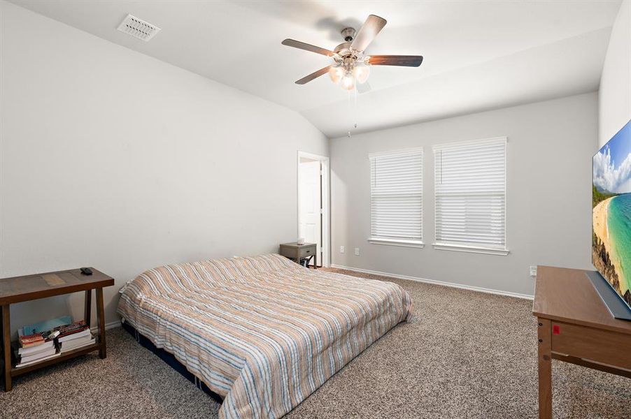 Carpeted bedroom with lofted ceiling and ceiling fan Carpeted bedroom with lofted ceiling and ceiling fan