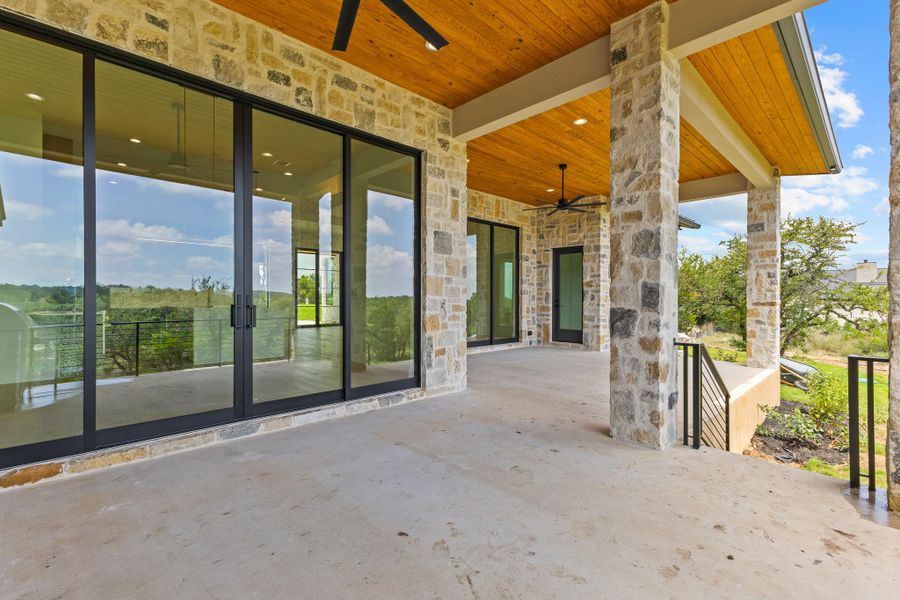 An inviting stone patio with wood ceilings extends the living space, offering picturesque outdoor enjoyment. An inviting stone patio with wood ceilings extends the living space, offering picturesque outdoor enjoyment.
