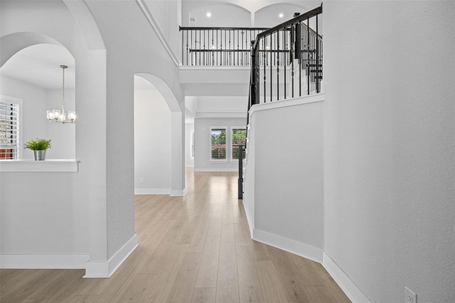 Elegant entrance foyer with a grand staircase and gleaming wood floors.