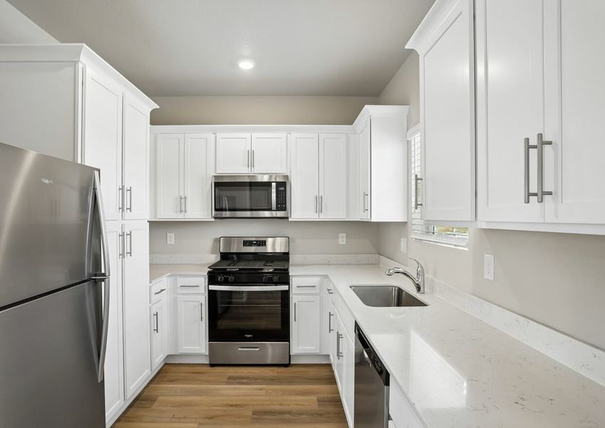 The kitchen has stainless steel appliance and plank flooring.