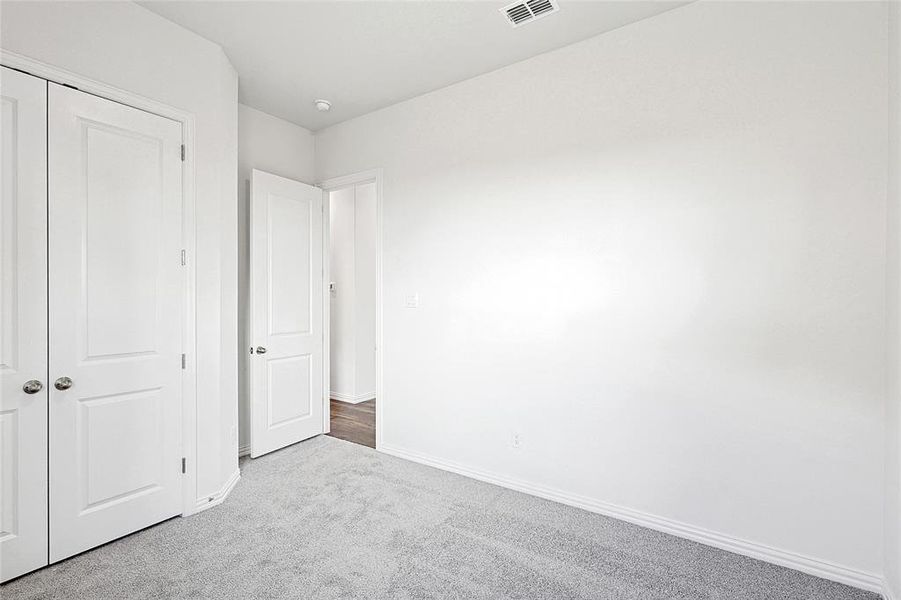 Unfurnished bedroom with a closet and light colored carpet