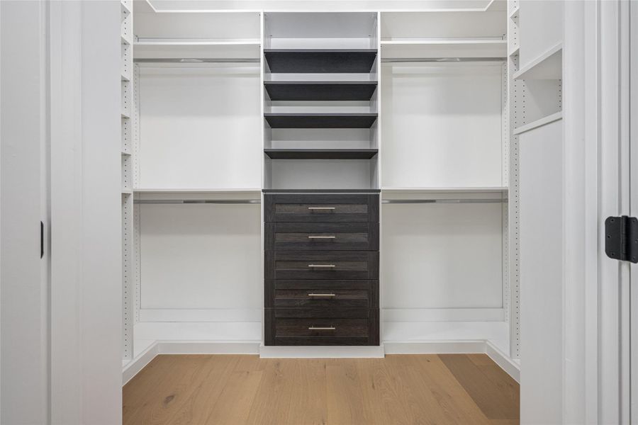 The primary closet is crafted with custom finishes to accommodate luxury wardrobes in style The primary closet is crafted with custom finishes to accommodate luxury wardrobes in style