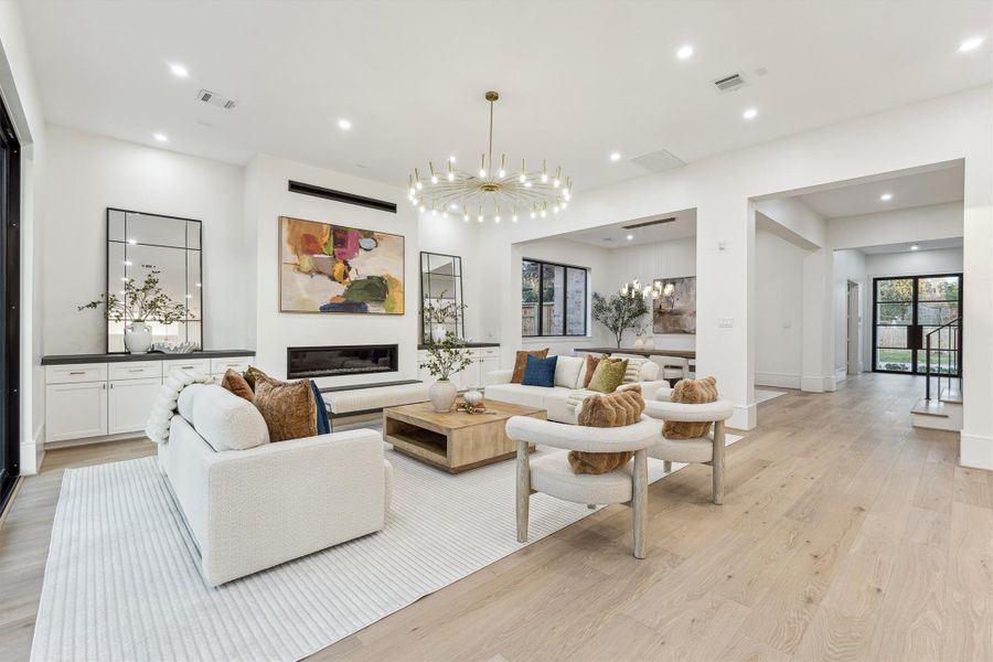 The living room boasts custom built-ins, a cozy gas fireplace, and a stunning chandelier that elevates the entire space.