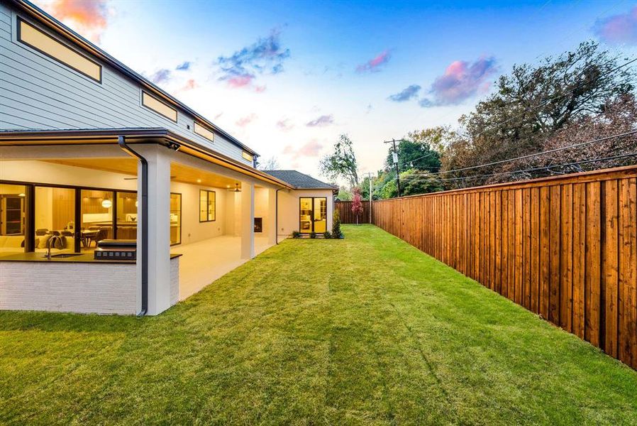 Yard at dusk with a patio and a fenced backyard Yard at dusk with a patio and a fenced backyard