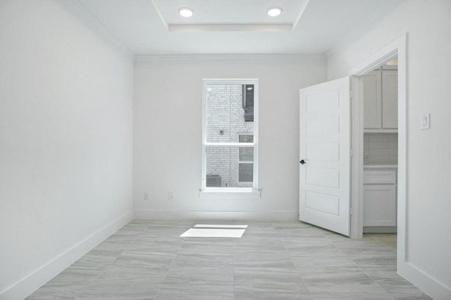 Unfurnished room with ornamental molding and a tray ceiling