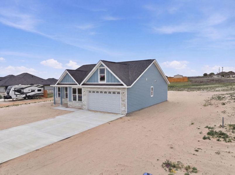 Front exterior of a new home in Las Palomas Country Club Estates, La Vernia, TX, highlighting curb appeal (Image 13).