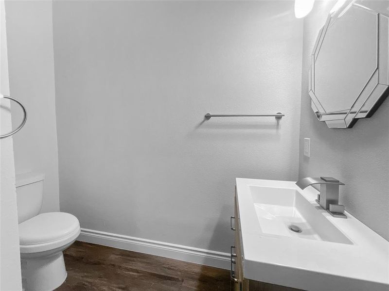 Bathroom with vanity, toilet, and hardwood / wood-style floors