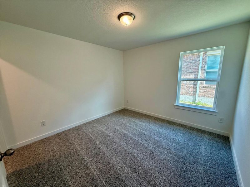 Carpeted spare room with baseboards and a textured ceiling Carpeted spare room with baseboards and a textured ceiling