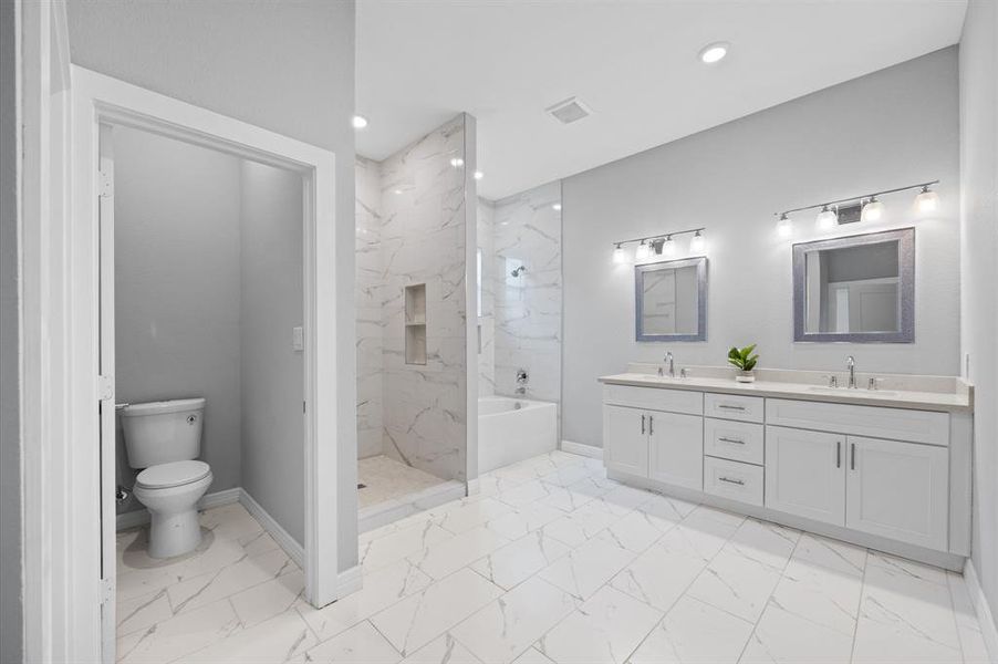 uxurious en-suite with a soaking tub, separate shower, and double sink vanity.