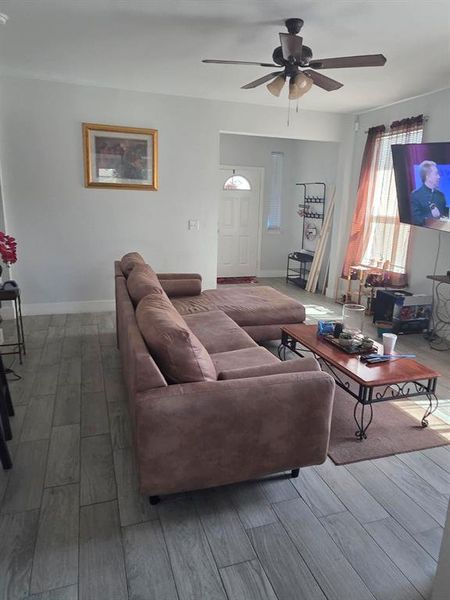 Living room with wood finished floors and a ceiling fan