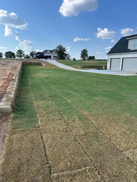 View of yard featuring a water view and a garage