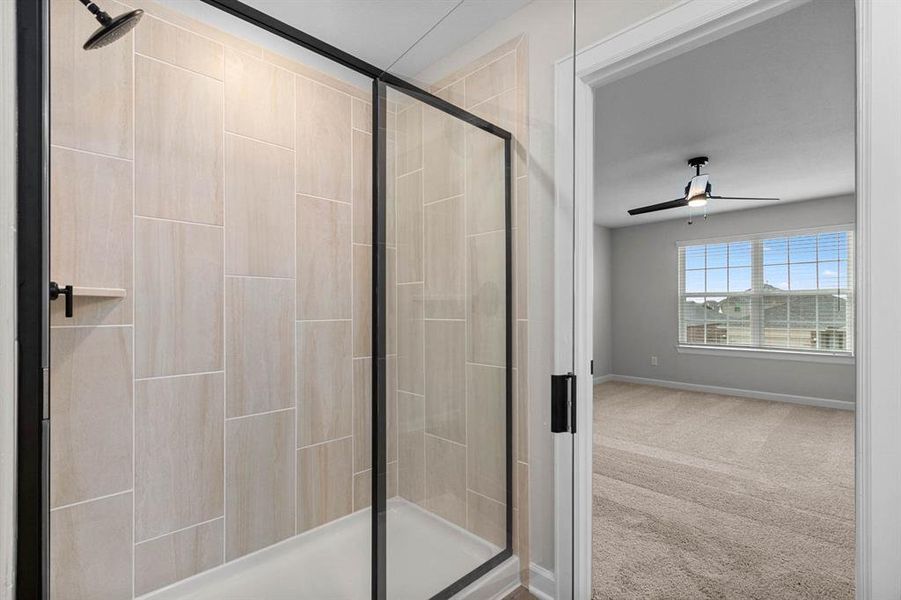 The primary bathroom has a spacious shower space and a soaking tub.