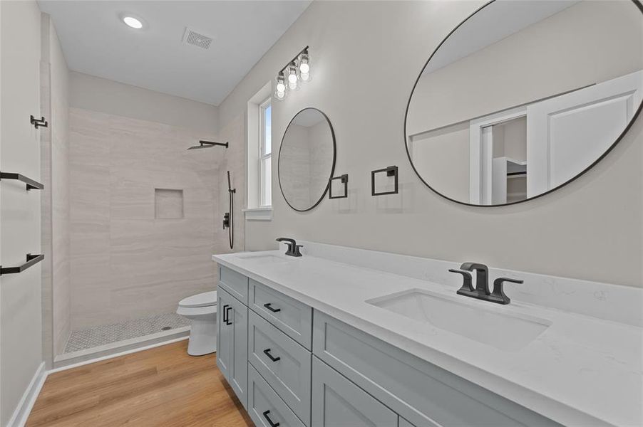 Primary bath has dual vanities as well as large walk-in shower.