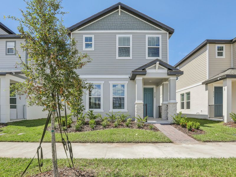Front exterior of a new home in The Meadow at Crossprairie Bungalows, St. Cloud, FL, highlighting curb appeal (Image 1).