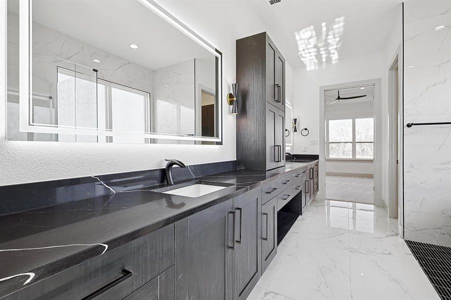 Full bathroom with light marble finish floors, double vanity, recessed lighting, and a ceiling fan Full bathroom with light marble finish floors, double vanity, recessed lighting, and a ceiling fan
