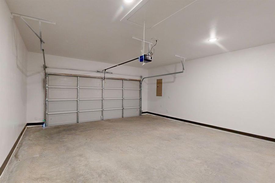 Garage featuring electric panel and a garage door opener