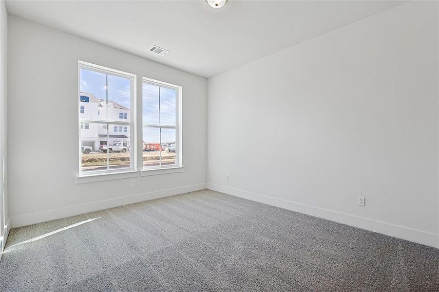 Empty room featuring light colored carpet and baseboards