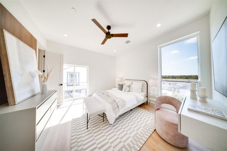 Bedroom with light hardwood / wood-style floors, multiple windows, and ceiling fan