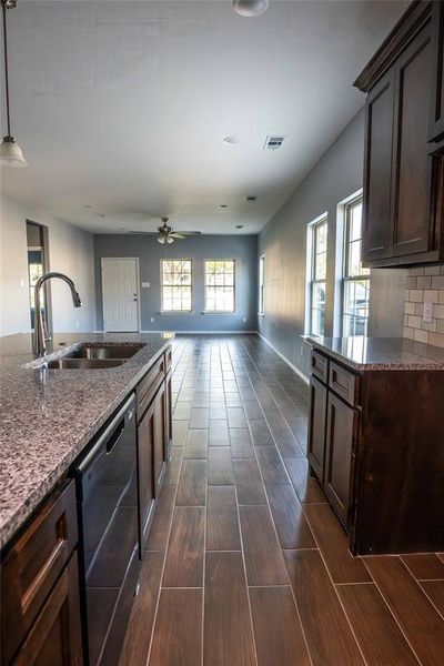 Kitchen with hanging light fixtures, plenty of natural light, stainless steel dishwasher, and sink