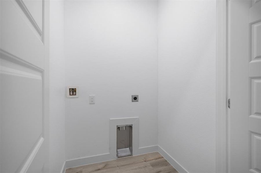 Laundry room featuring hookup for an electric dryer, light wood-type flooring, and hookup for a washing machine Laundry room featuring hookup for an electric dryer, light wood-type flooring, and hookup for a washing machine