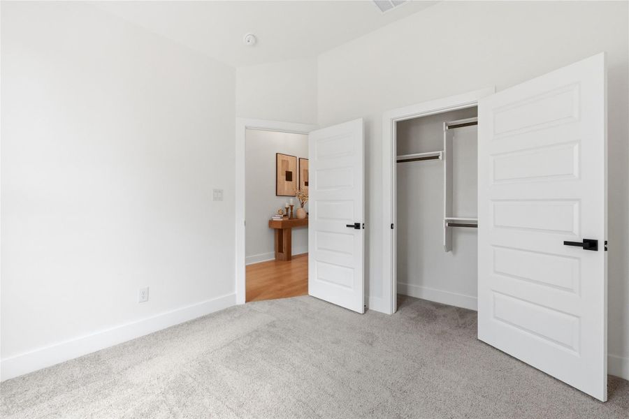 Unfurnished bedroom featuring light carpet and a closet