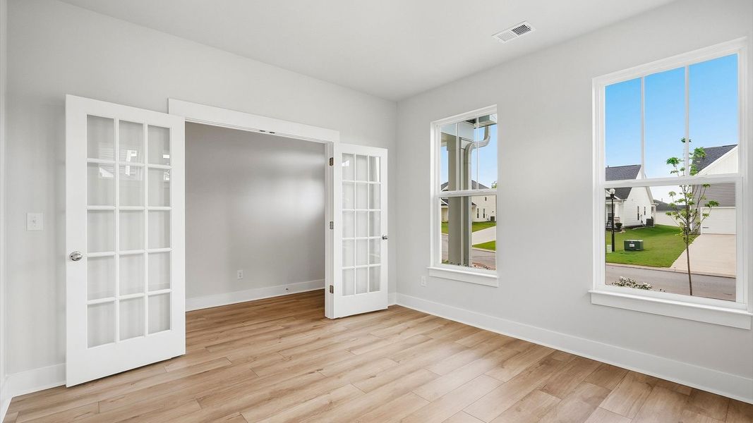 Vibrant natural light and tasteful design define this French door study near the front of the home by DRB Homes