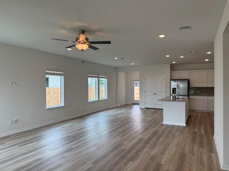 Open-concept living area featuring wood-finish flooring, recessed lighting, and a ceiling fan