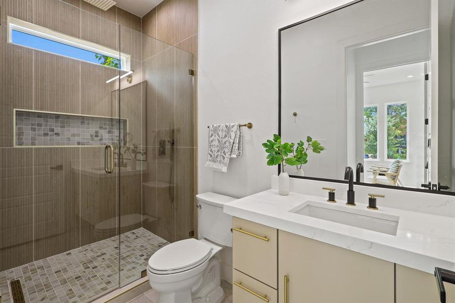 Bathroom featuring toilet, vanity, a shower with shower door, and a healthy amount of sunlight