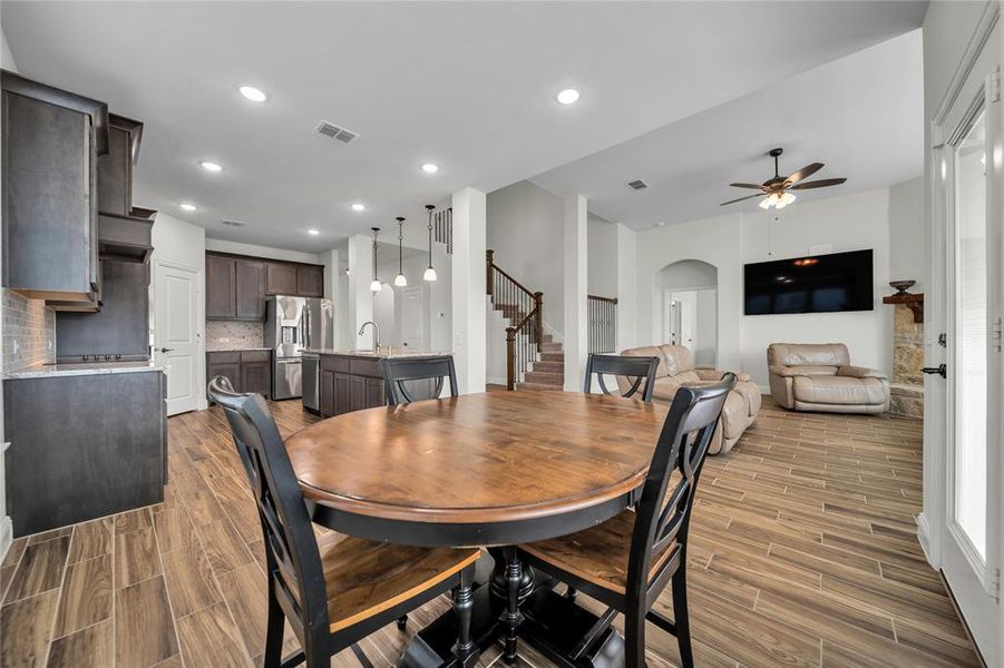 Dining space featuring stairway, wood finish floors, arched walkways, ceiling fan, and recessed lighting Dining space featuring stairway, wood finish floors, arched walkways, ceiling fan, and recessed lighting