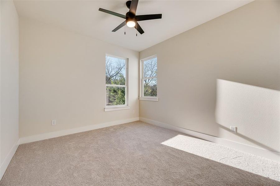 Carpeted empty room with baseboards and ceiling fan Carpeted empty room with baseboards and ceiling fan