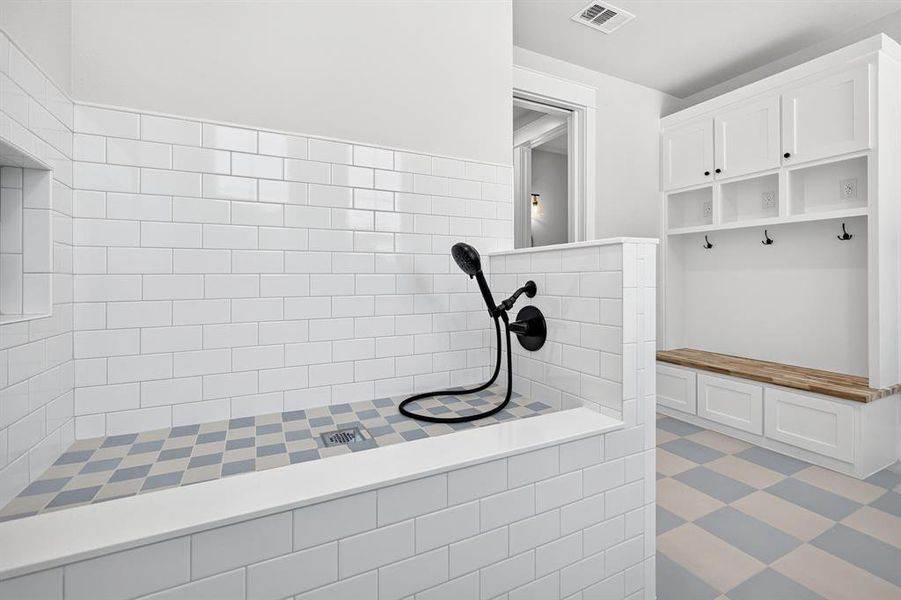 The ultimate mudroom entry, thoughtfully designed with custom storage built-ins and a dedicated, tiled pet/dog wash station for effortless cleanup. The ultimate mudroom entry, thoughtfully designed with custom storage built-ins and a dedicated, tiled pet/dog wash station for effortless cleanup.