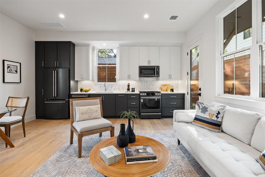 Living room with light hardwood / wood-style floors and sink