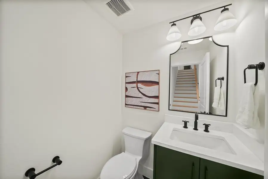 Bathroom featuring a custom green vanity with a white countertop and integrated sink Bathroom featuring a custom green vanity with a white countertop and integrated sink