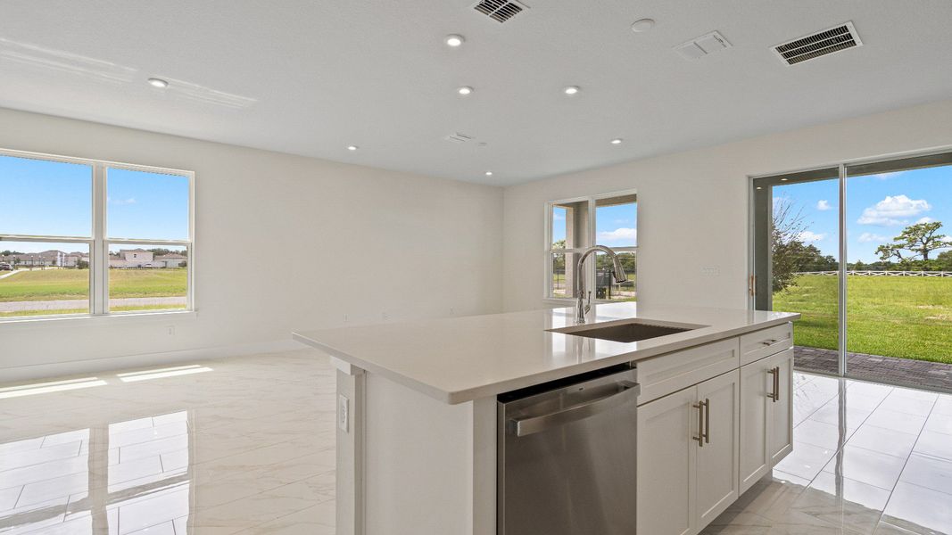 The Sweetgum Spacious and Bright Kitchen with large Island in two story home in Trailside in Mount Dora by DRB Homes