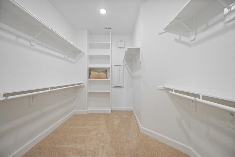 Experience the luxury of a large walk-in closet featuring custom shelves, perfect for keeping your wardrobe organized and accessible.