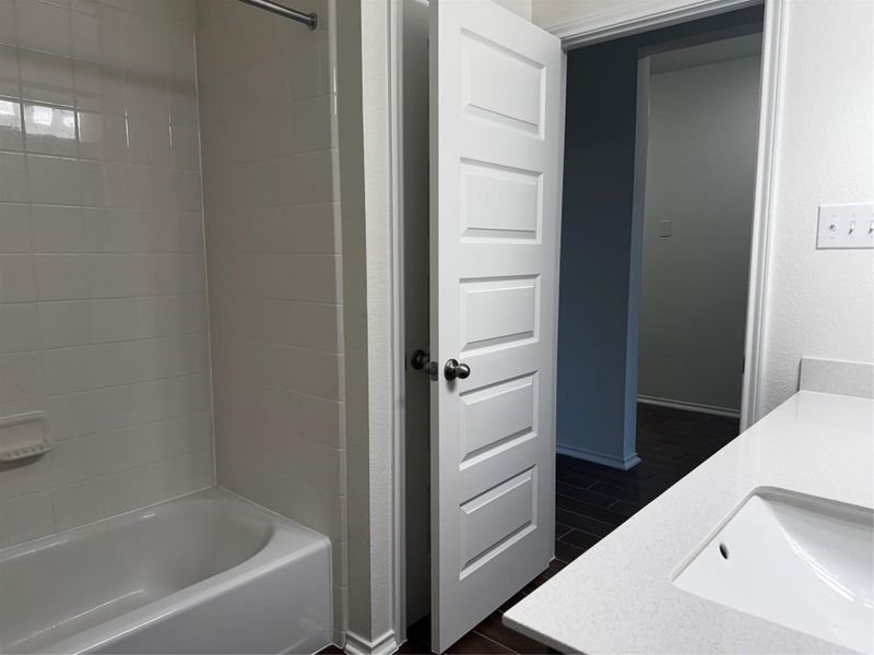 Full bathroom with bathtub / shower combination, and wood-like title floors