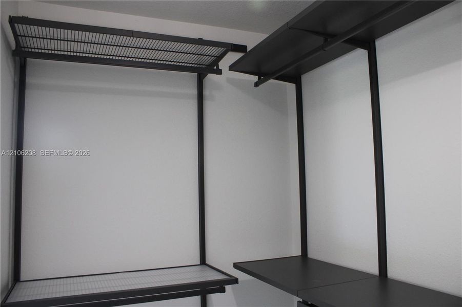 Built-in closet system featuring matte black metal framing, integrated shelving, and wire rack storage components