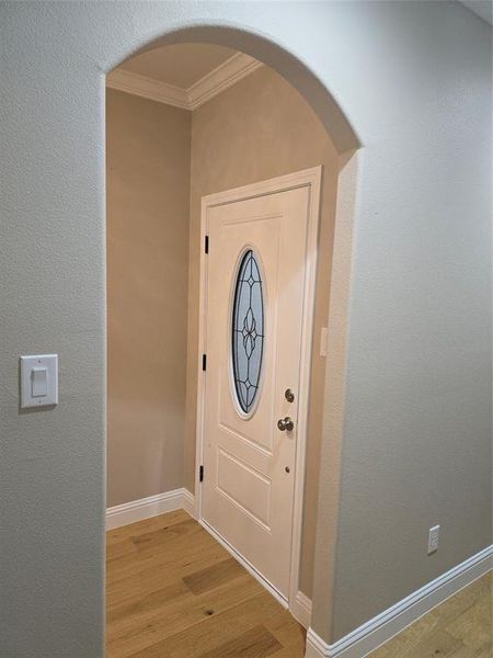 Entrance foyer featuring light wood-type flooring and ornamental molding