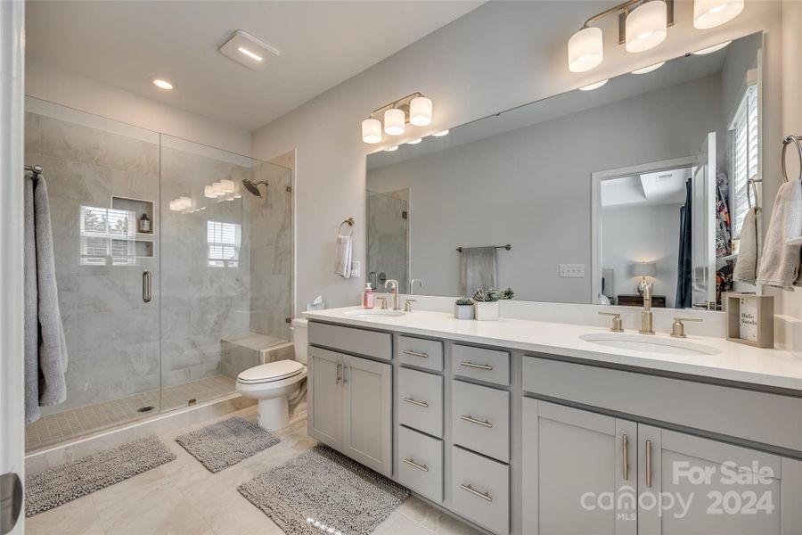 Oversized primary bathroom with dual vanities and incredible tiled shower!