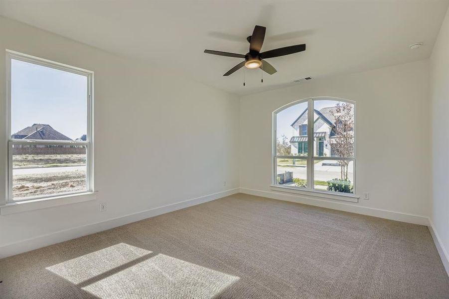 Empty room featuring light colored carpet and ceiling fan Empty room featuring light colored carpet and ceiling fan