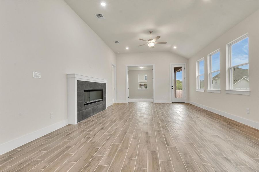 Vast main living area with high ceilings, recessed lighting, and a contemporary fireplace.