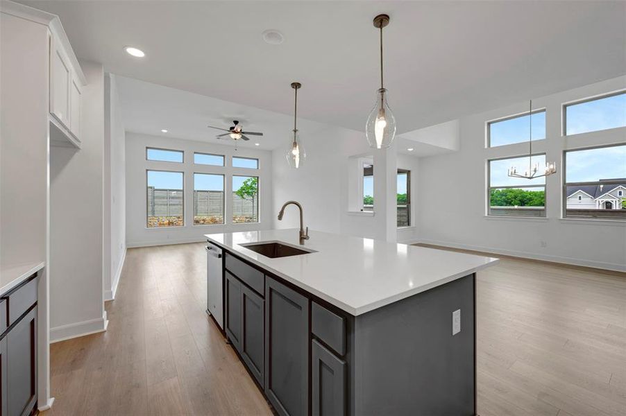The kitchen features a large island with a sink and a light-colored countertop