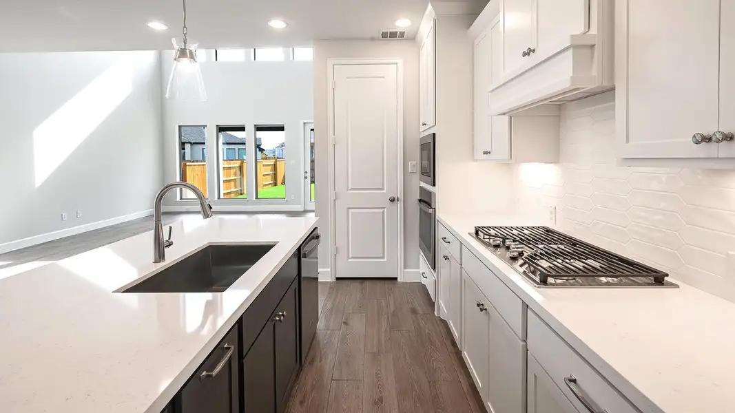 Kitchen featuring dark cabinets, dark wood-style floors, recessed lighting, light stone countertops, and white cabinetry
